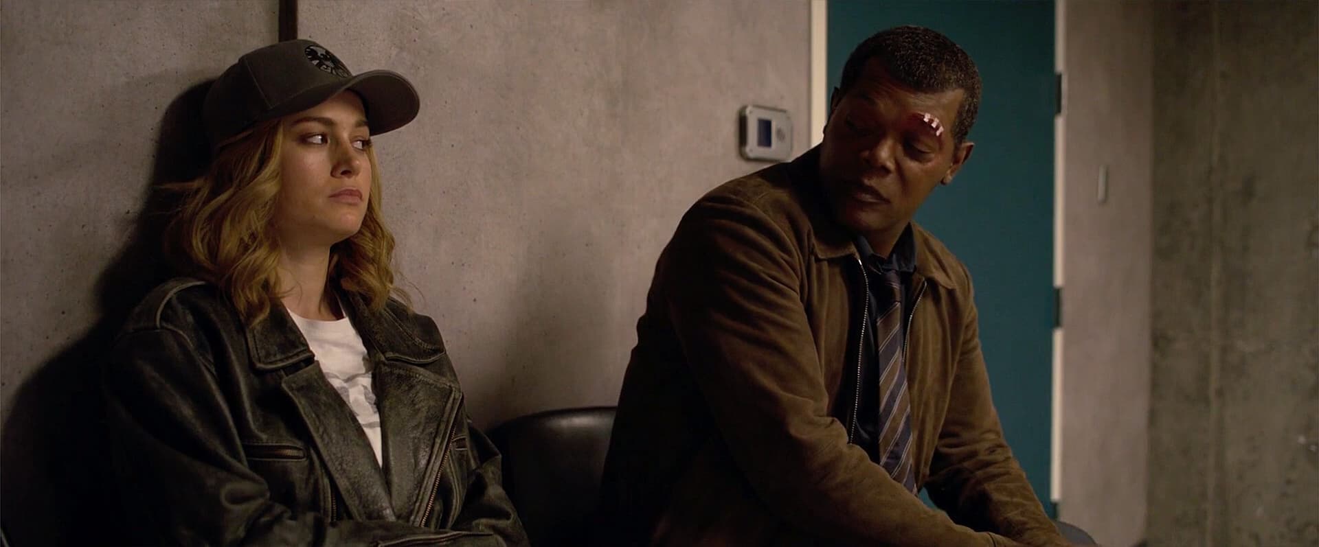 A woman (Captain Marvel) and a man (Nick Fury) sit and have a discussion