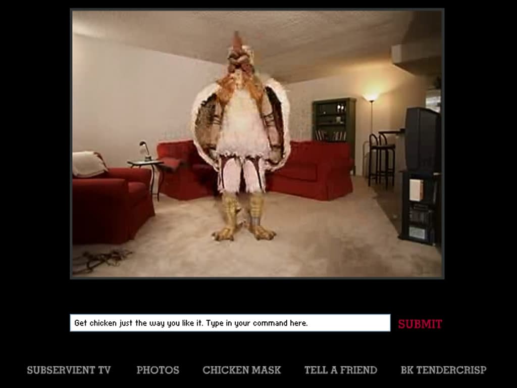 Screenshot of the Subservient Chicken website, featuring a costumed person dressed as a chicken standing in a living room. The interface includes a text input field with the prompt, ‘Get chicken just the way you like it. Type in your command here,’ and a red ‘Submit’ button. Below, navigation links include options like Subservient TV, Photos, Chicken Mask, Tell a Friend, and BK TenderCrisp.