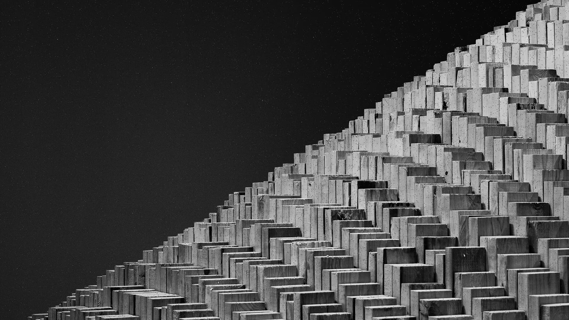 Geometric pattern of stacked rectangular blocks forming a diagonal structure against a dark sky. Artwork by Maya Lin.